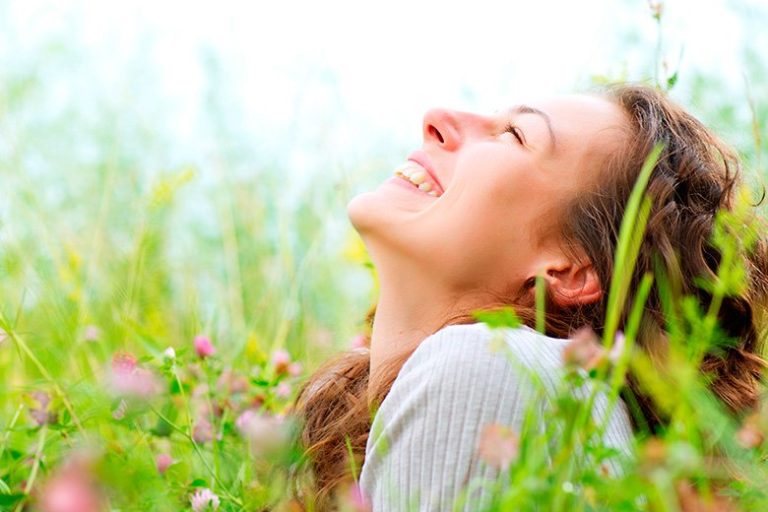 Ragazza di buonumore in un campo di fiori in primavera