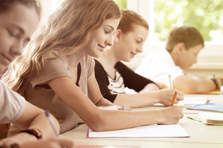 Ragazza di buonumore scrive a scuola